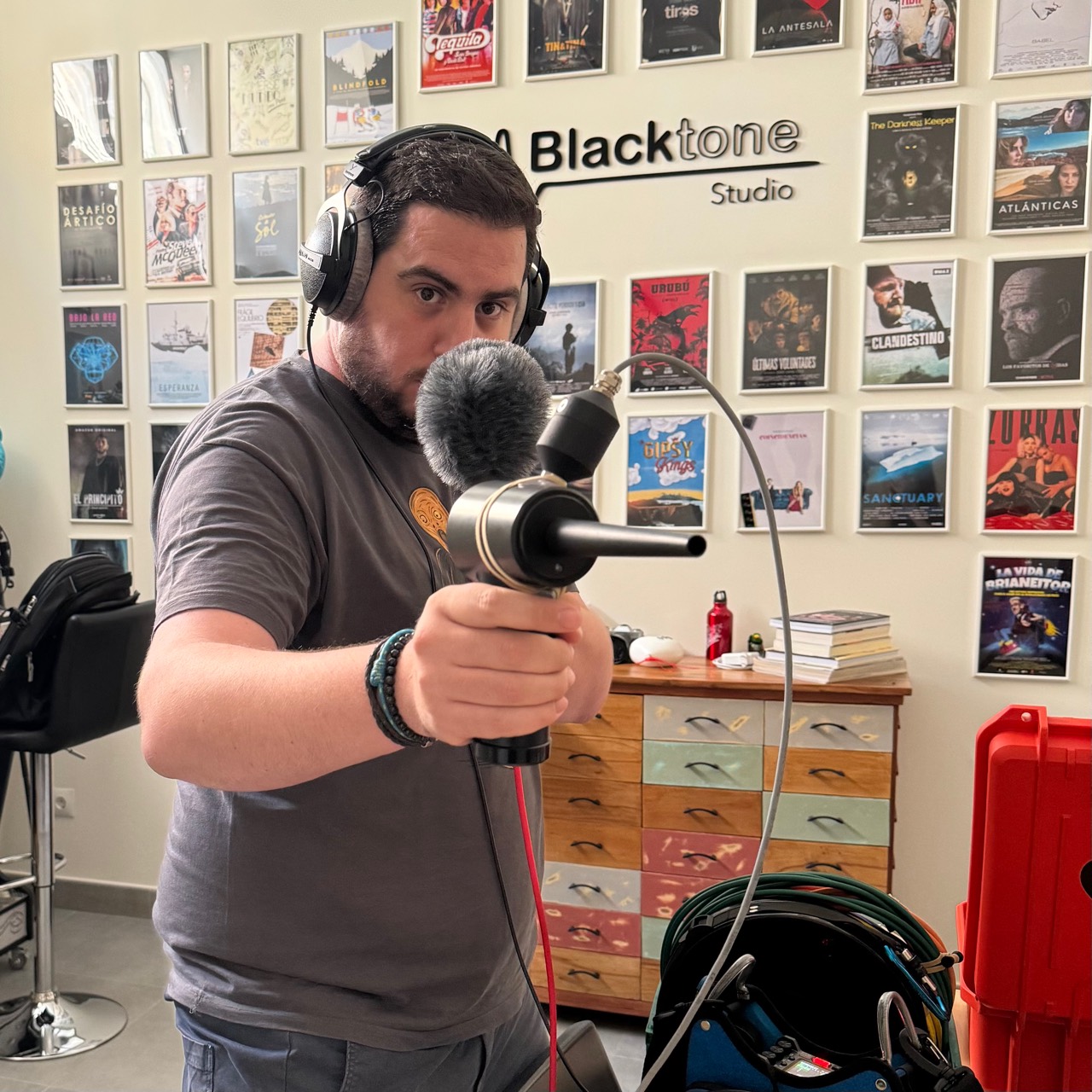 Álvaro de Iscar testing a microphone with headphones at Blacktone Studio while preparing equipment for field recording.